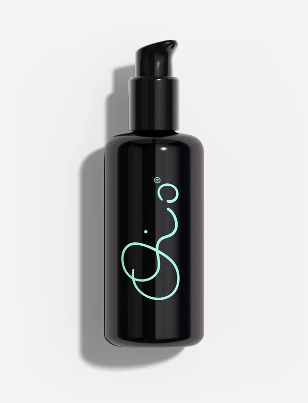 Oio Lab Omega Milk black pump bottle with a glowing mint green abstract logo, set against a clean white background with a soft shadow.