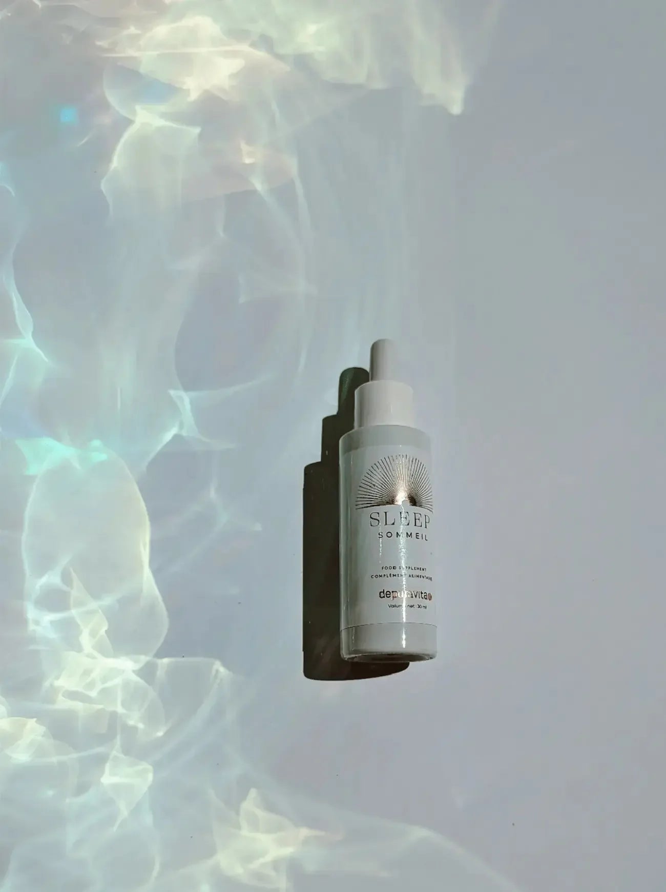 White bottle of Depuravita Sleep Facial Serum with dropper on white table.