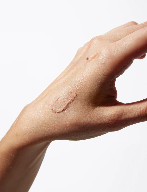 Close up of creamy highlighter balm texture with light reflecting mineral pigments