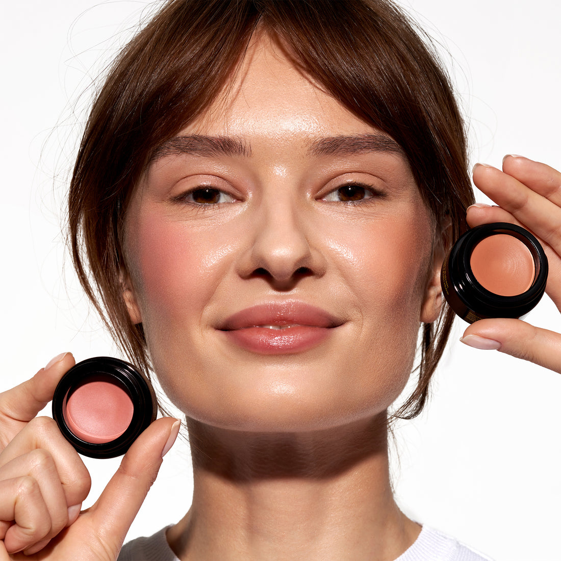 Model applying OIO Lab Melting Blush to cheeks for a natural healthy glow