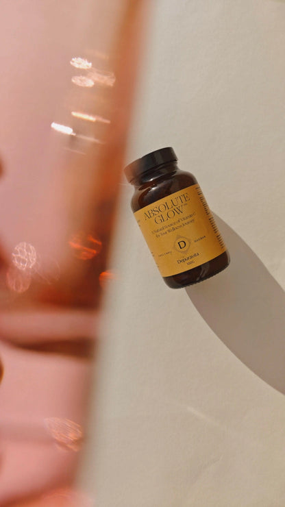 Brown bottle with yellow label "Absolute Glow" supplement by Depuravita.